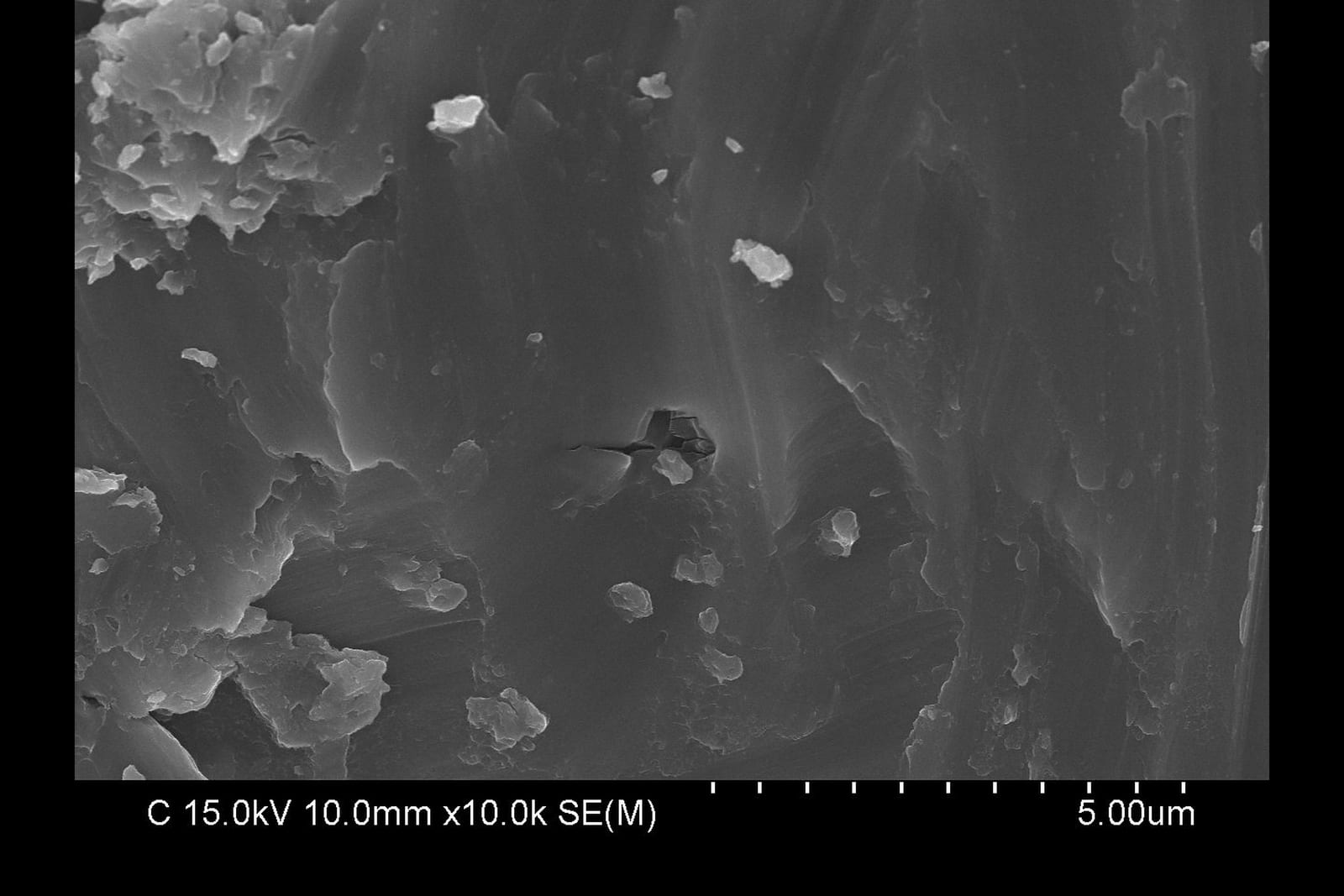 Scanning electron micrograph at 10,000x of the implant surface after mechanical debridement